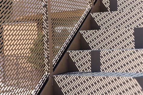 Detail perforovaného kovového podhľadu s geometrickým vzorom