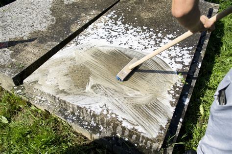 detailná fotografia ruky používajúcej fixku na nápis náhrobného kameňa