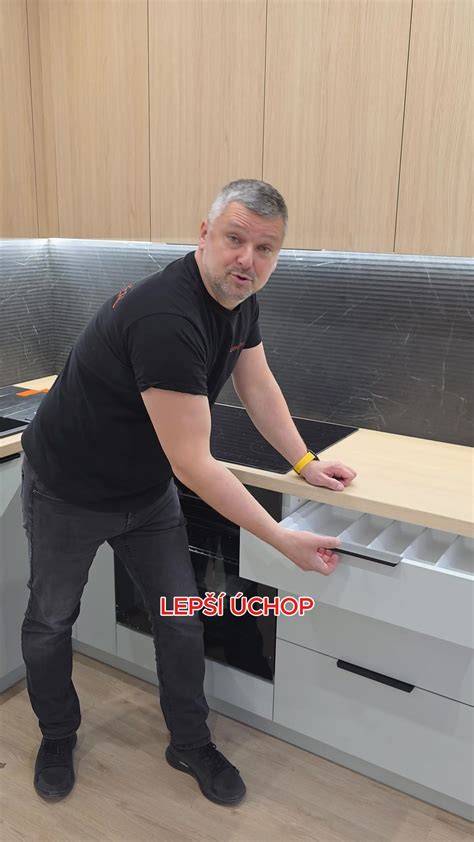 Obkladač dokončuje prácu pri už osadenej kuchynskej linke