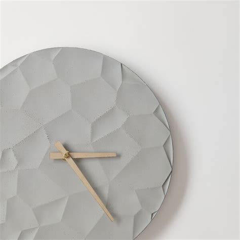 Minimalistické betónové nástenné hodiny v modernom interiéri