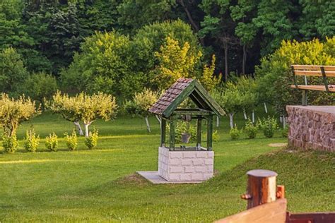 Dekoratívna studňa obložená tehlovými pásikmi v záhrade