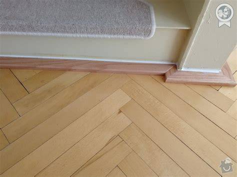Detailný záber na tmelenie škár v drevenej parketovej podlahe