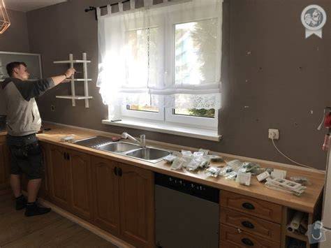 detail inštalácie skleneného obkladu nad kuchynskou linkou